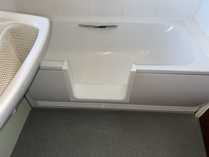 The open step-in frame cut into a customer's bath, with the anti-slip base visible