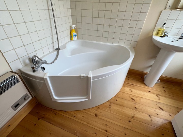 A UDOOR® bathtub door fitted into a customer's corner bath, door closed
