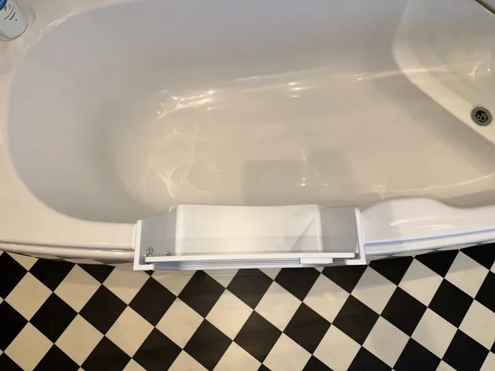A UDOOR® door fitted into a corner bath